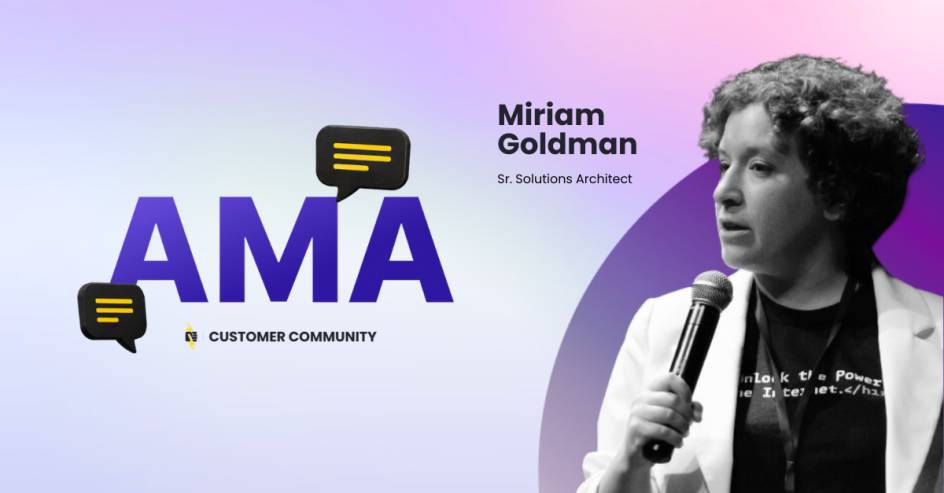 Miriam Goldman holding a mic giving a talk with a white suit jacket and black shirt
