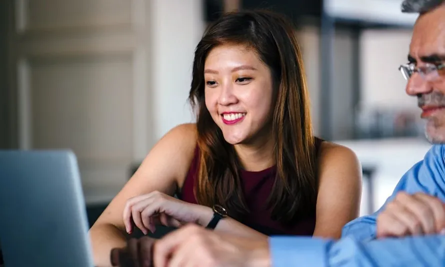 Two people behind a computer collaborating