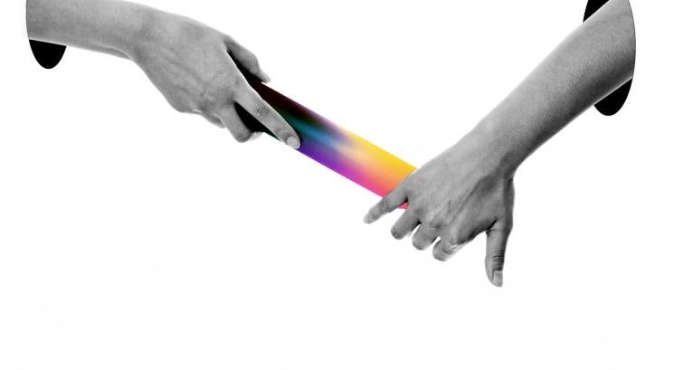 Hands passing a multicolored baton