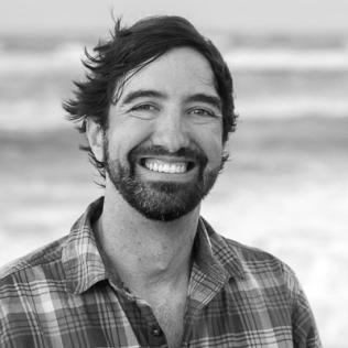 Black and white image of Kevin in front of a body of water