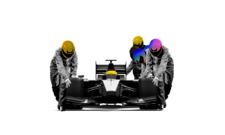 Race car with a driver in a helmet in it, with three other people in helmets pushing the race car along.